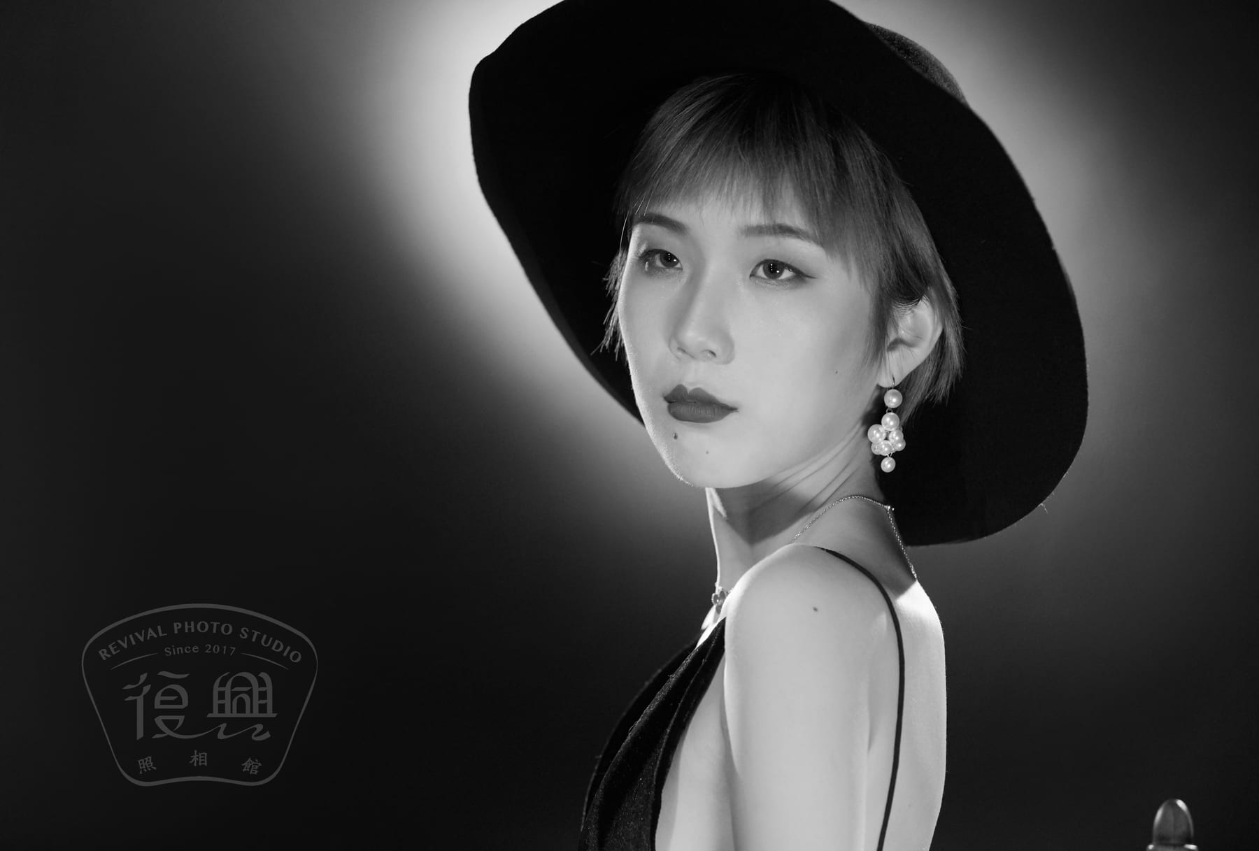 黑白肖像：戴宽檐帽的女性侧身回望