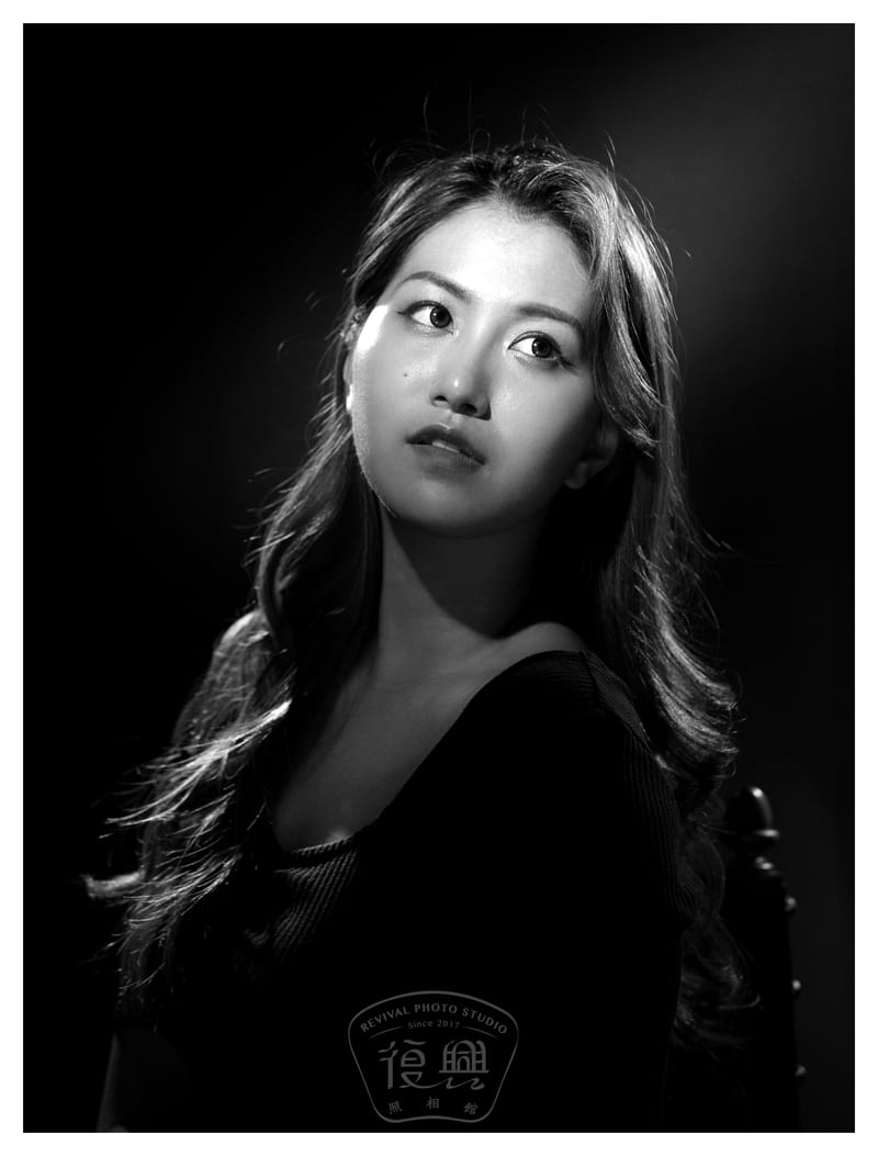黑白肖像：女性微微抬头，看向画外